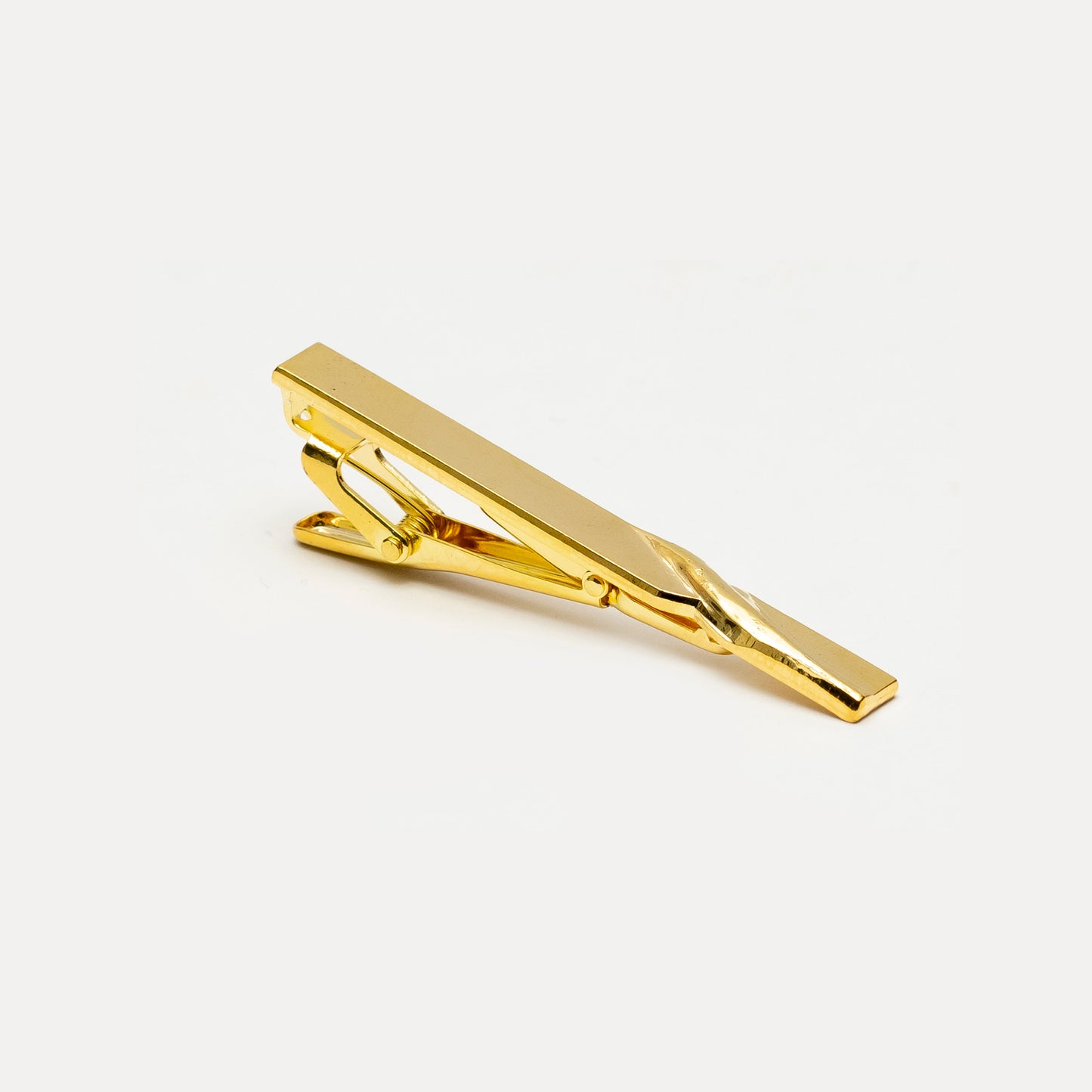 Gold tie clip on a white background