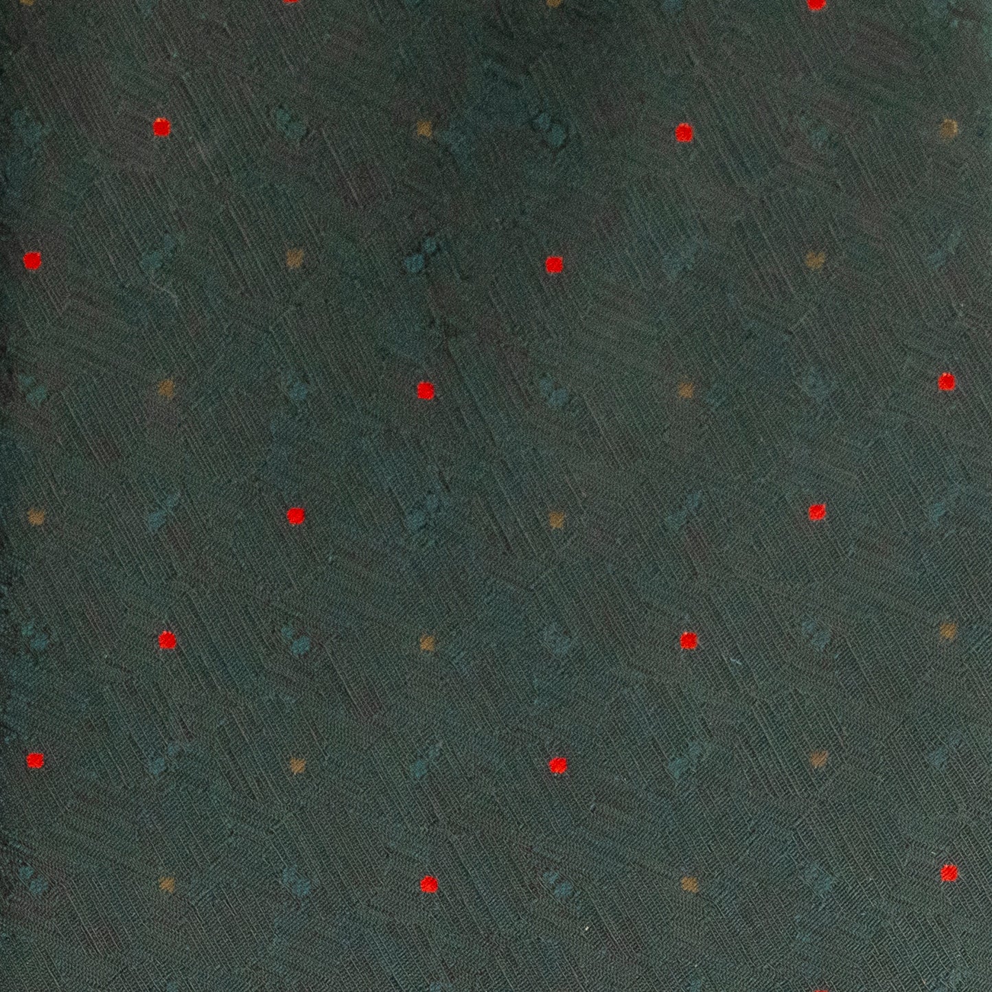 Textured dark green surface with red and gold specks