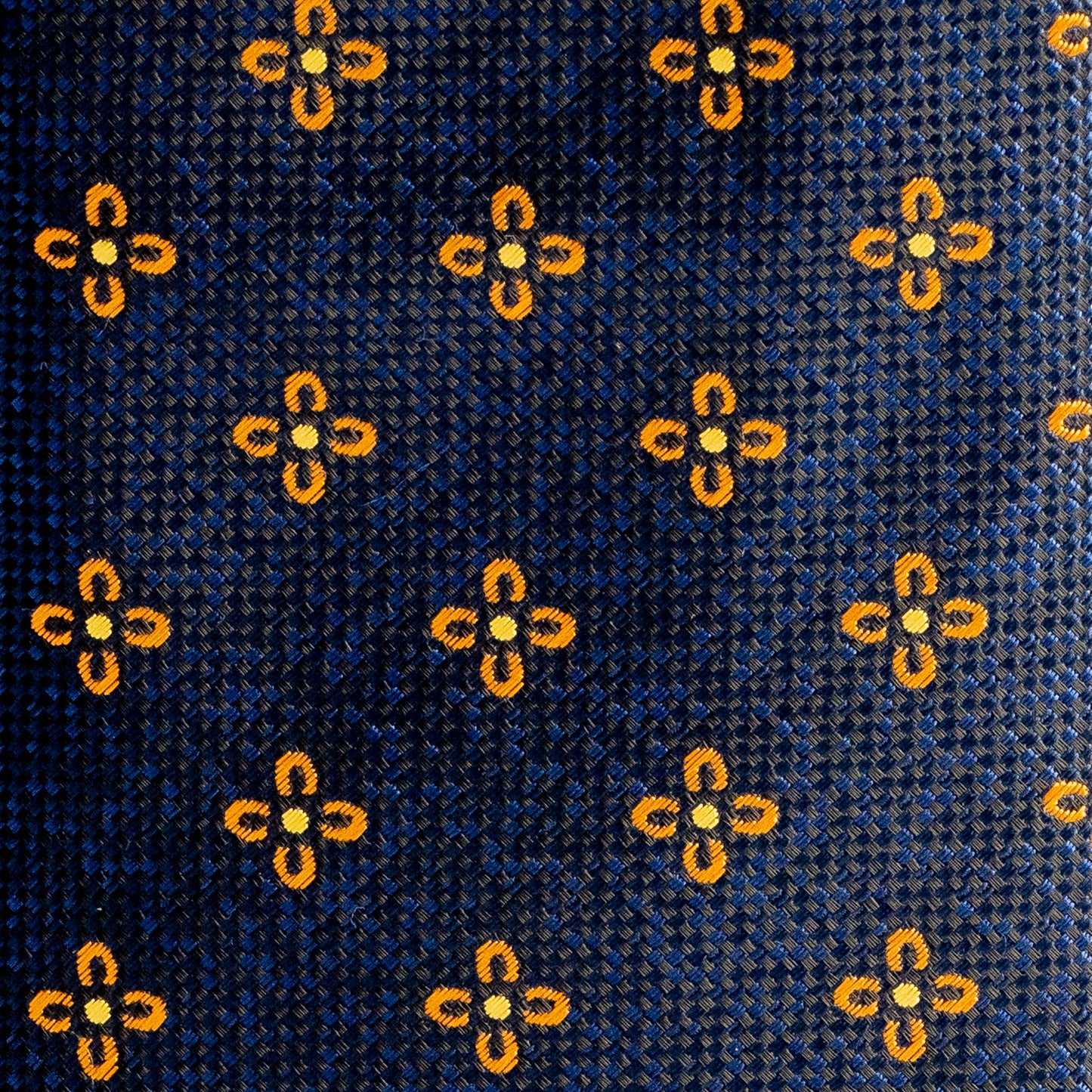 Close-up of a patterned fabric with yellow floral designs on a blue background