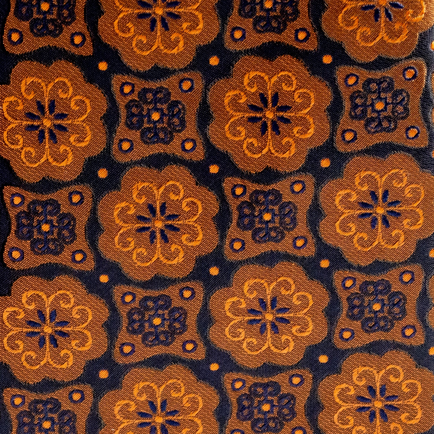 Patterned fabric with gold and blue floral designs on a dark background