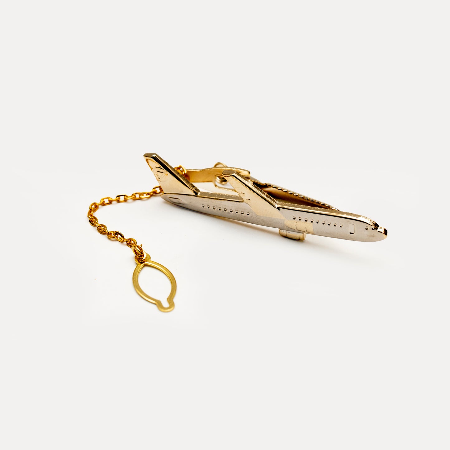 Gold airplane-shaped tie clip on a white background