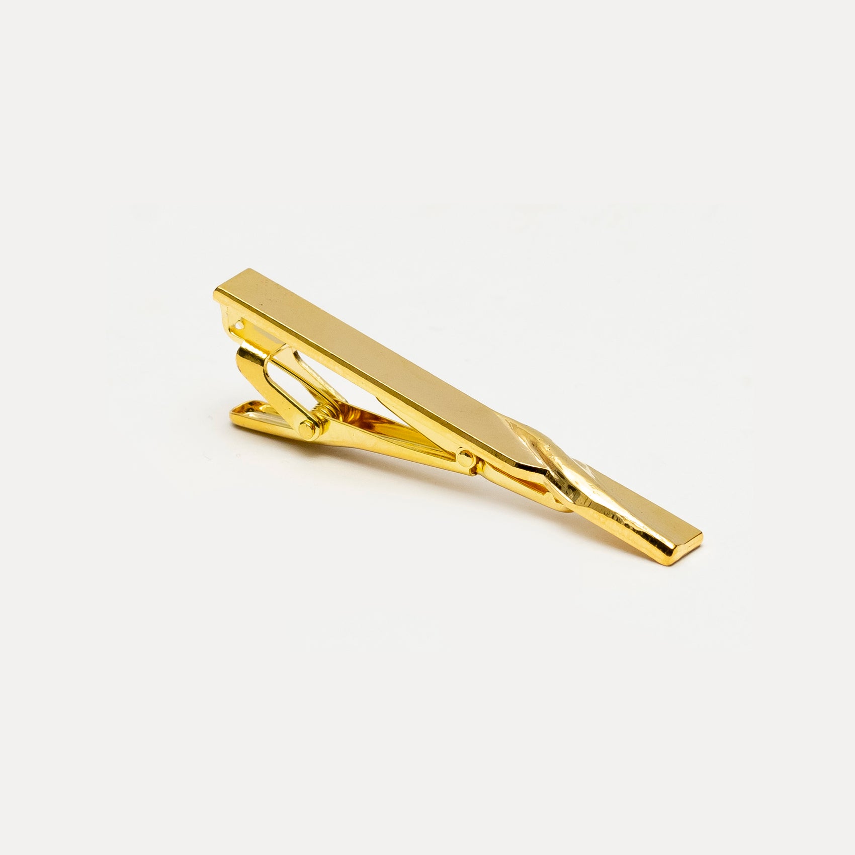 Gold tie clip on a white background