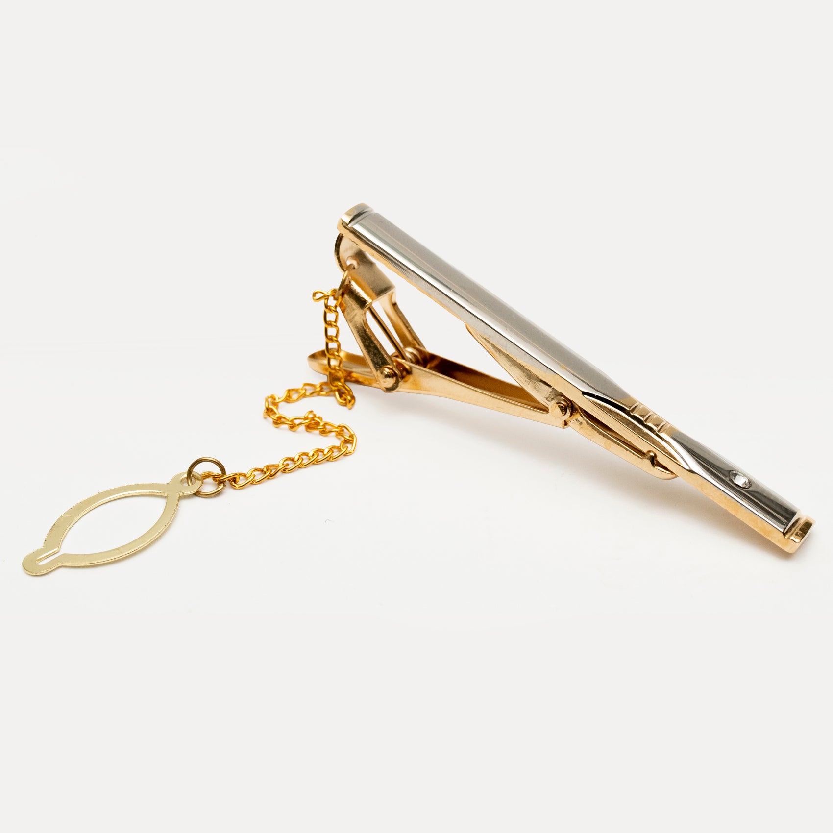 Gold tie clip with chain on a white background
