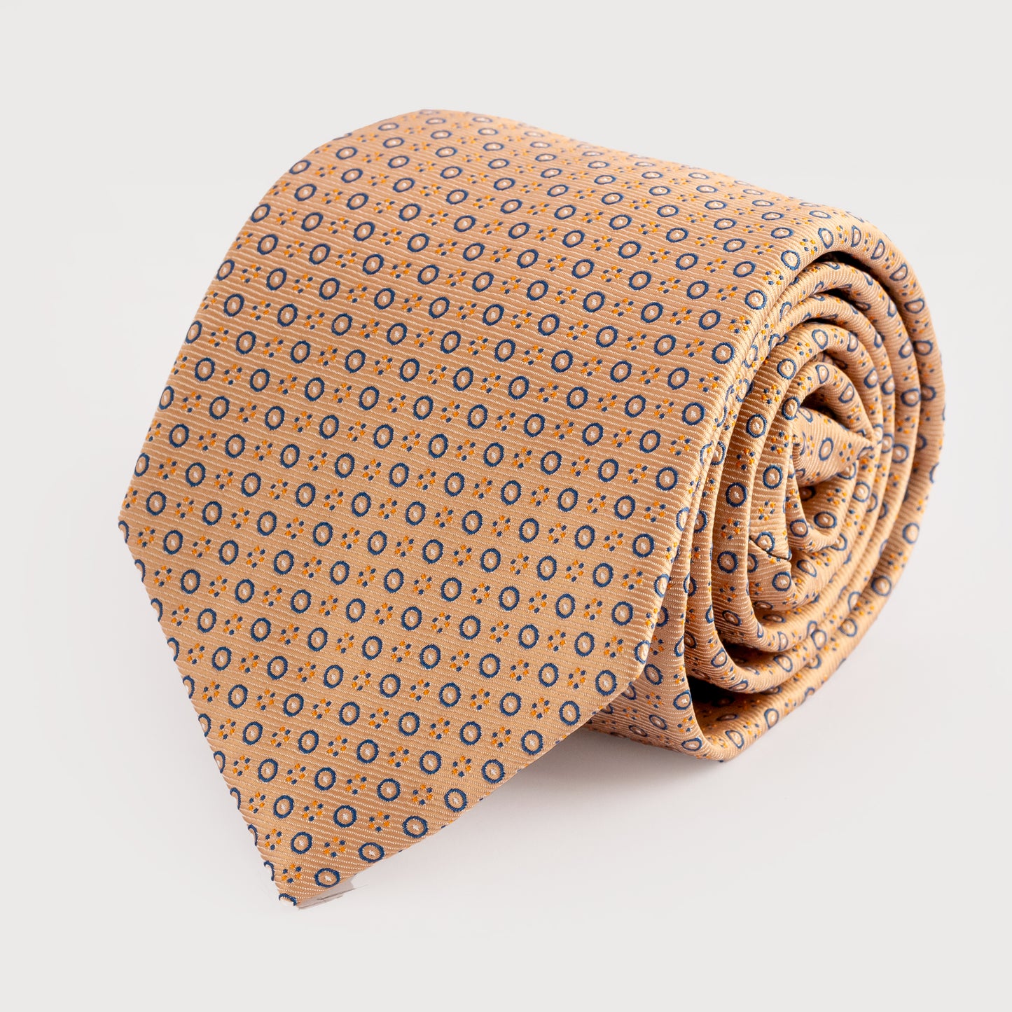 Rolled-up patterned tie on a light gray background