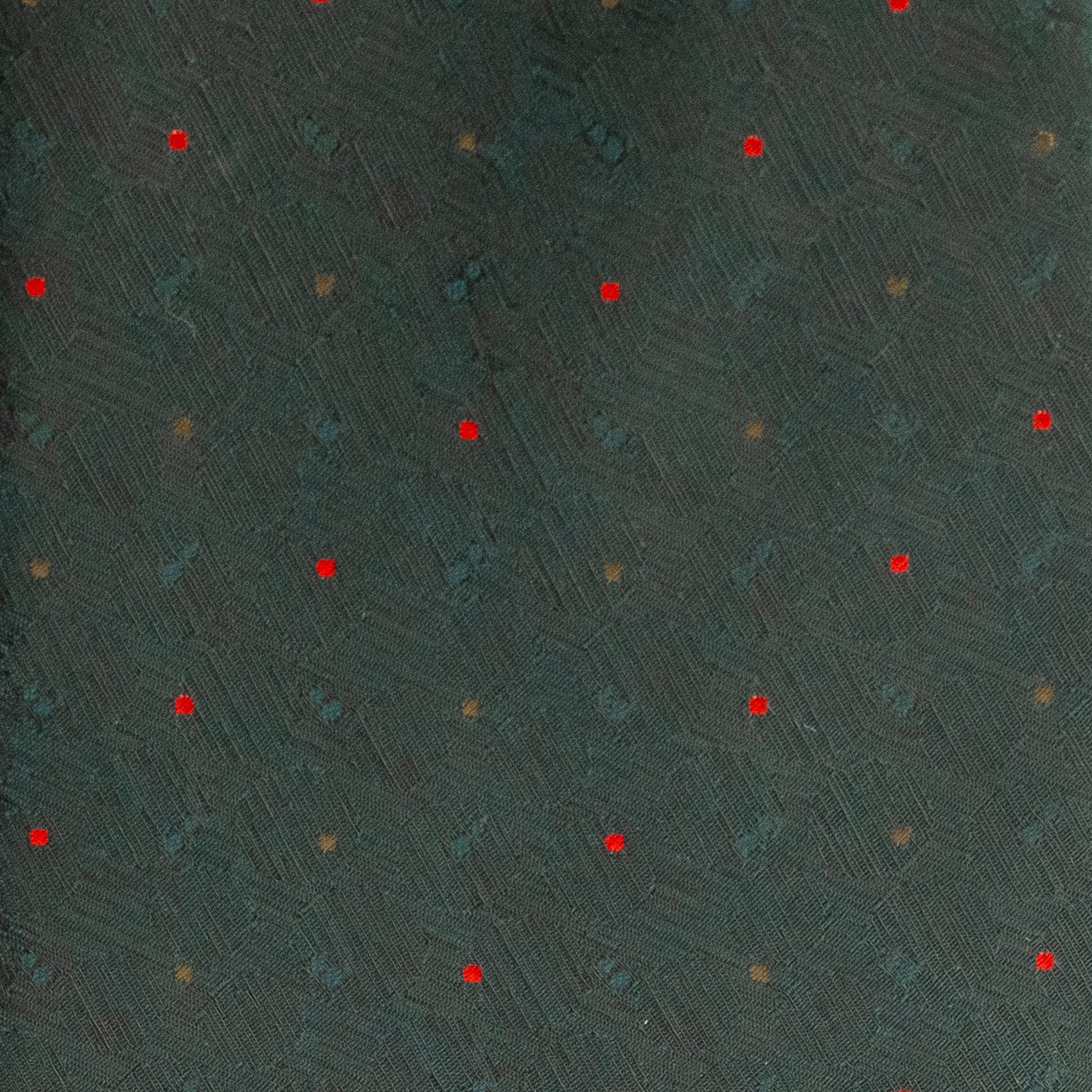 Textured dark green surface with red and gold specks