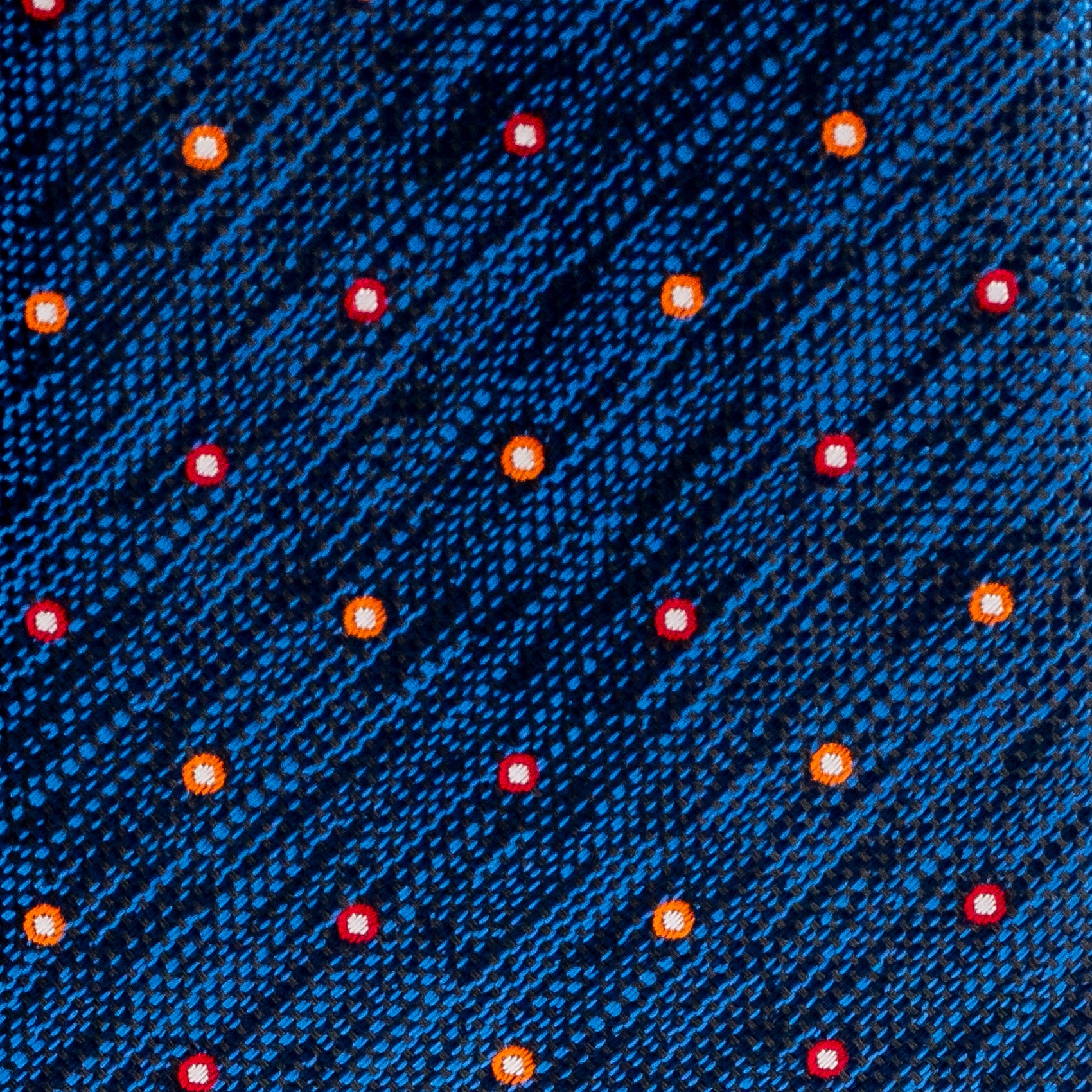 Close-up of a blue fabric with red and orange dots