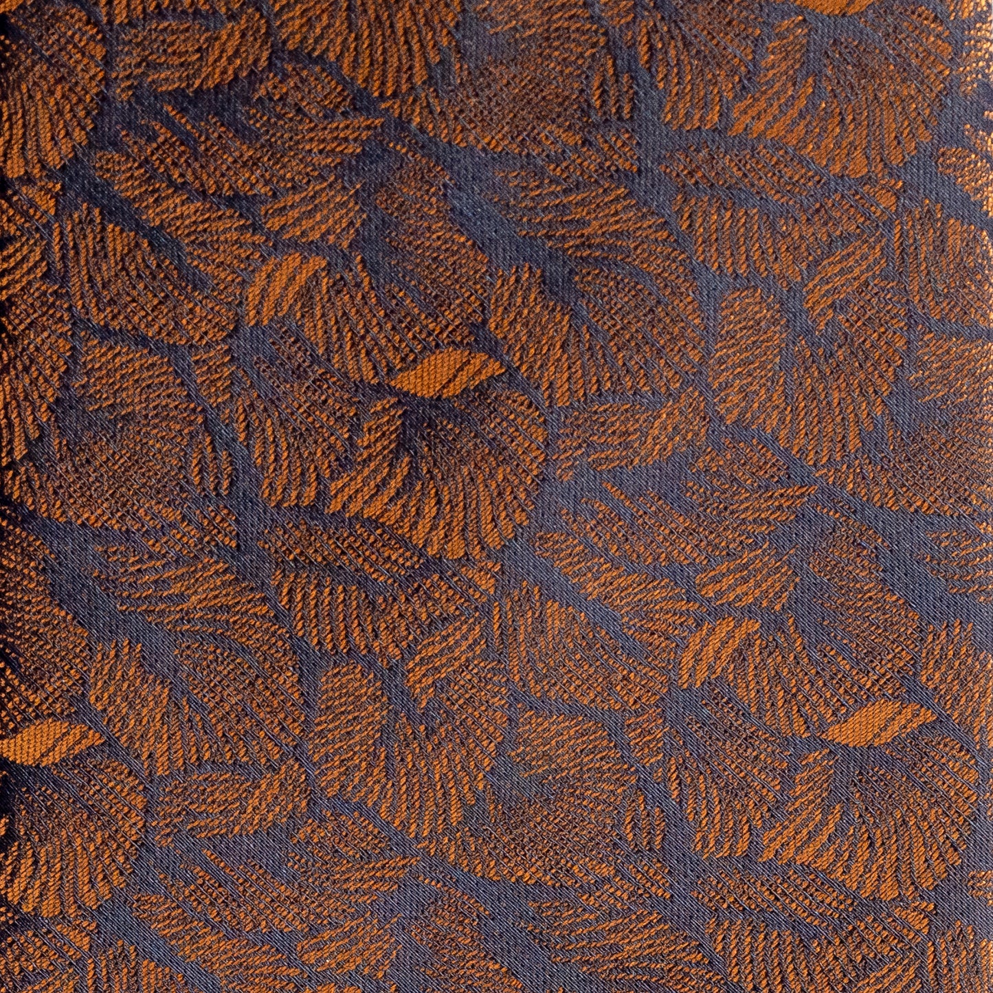Textured fabric with a leaf pattern in brown and blue.
