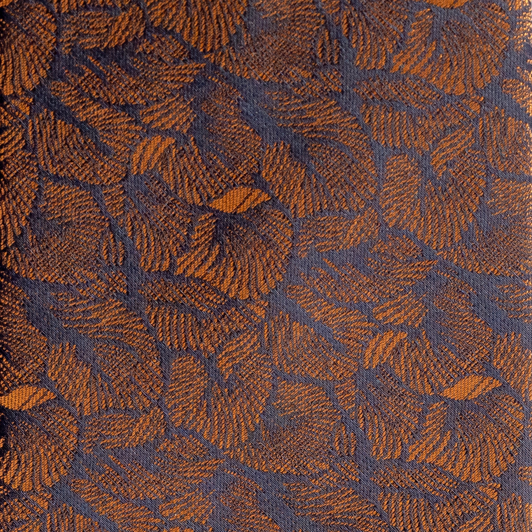 Textured fabric with a leaf pattern in brown and blue.
