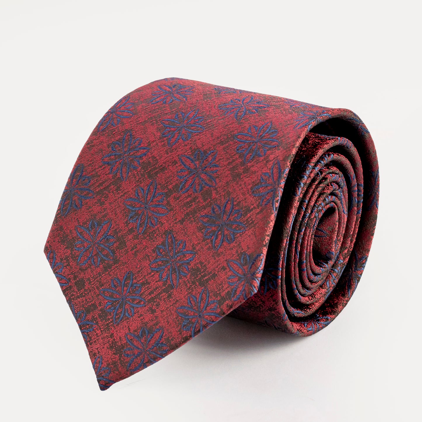 Roll of red fabric with blue floral pattern on a white background