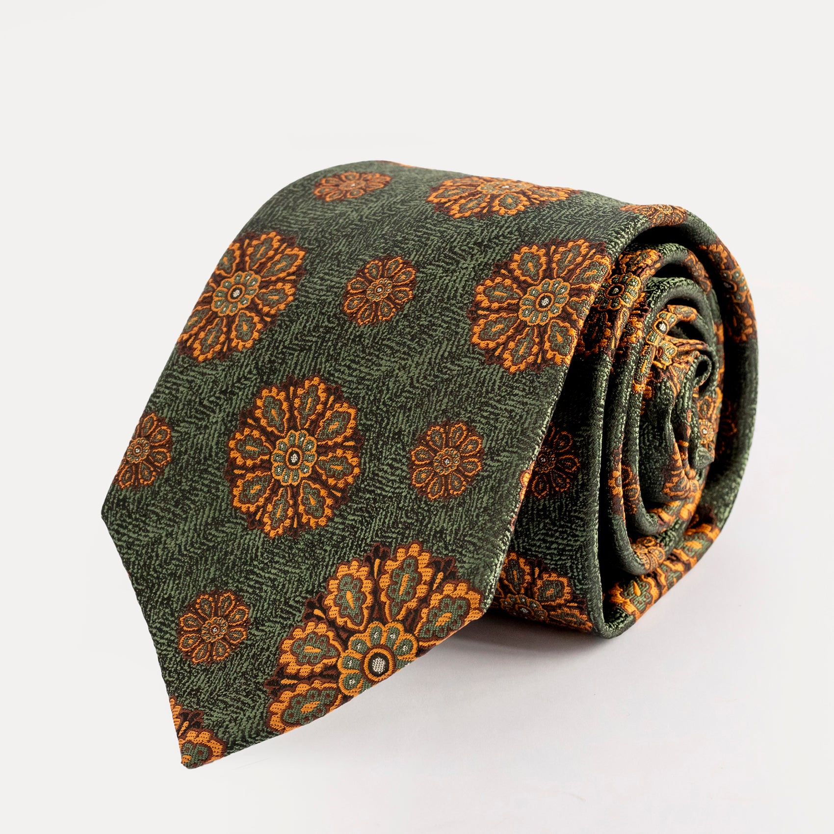 Green tie with brown floral pattern on a white background