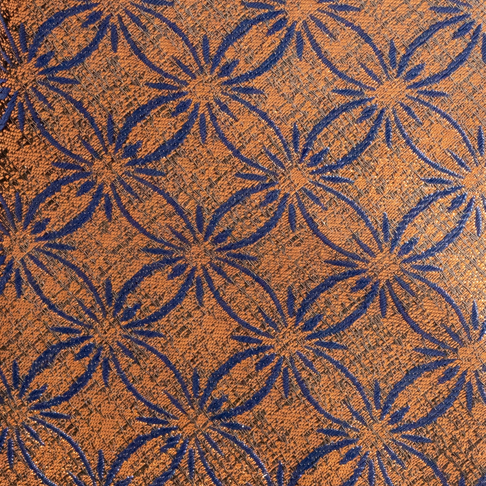 Patterned fabric with blue starburst design on a brown background