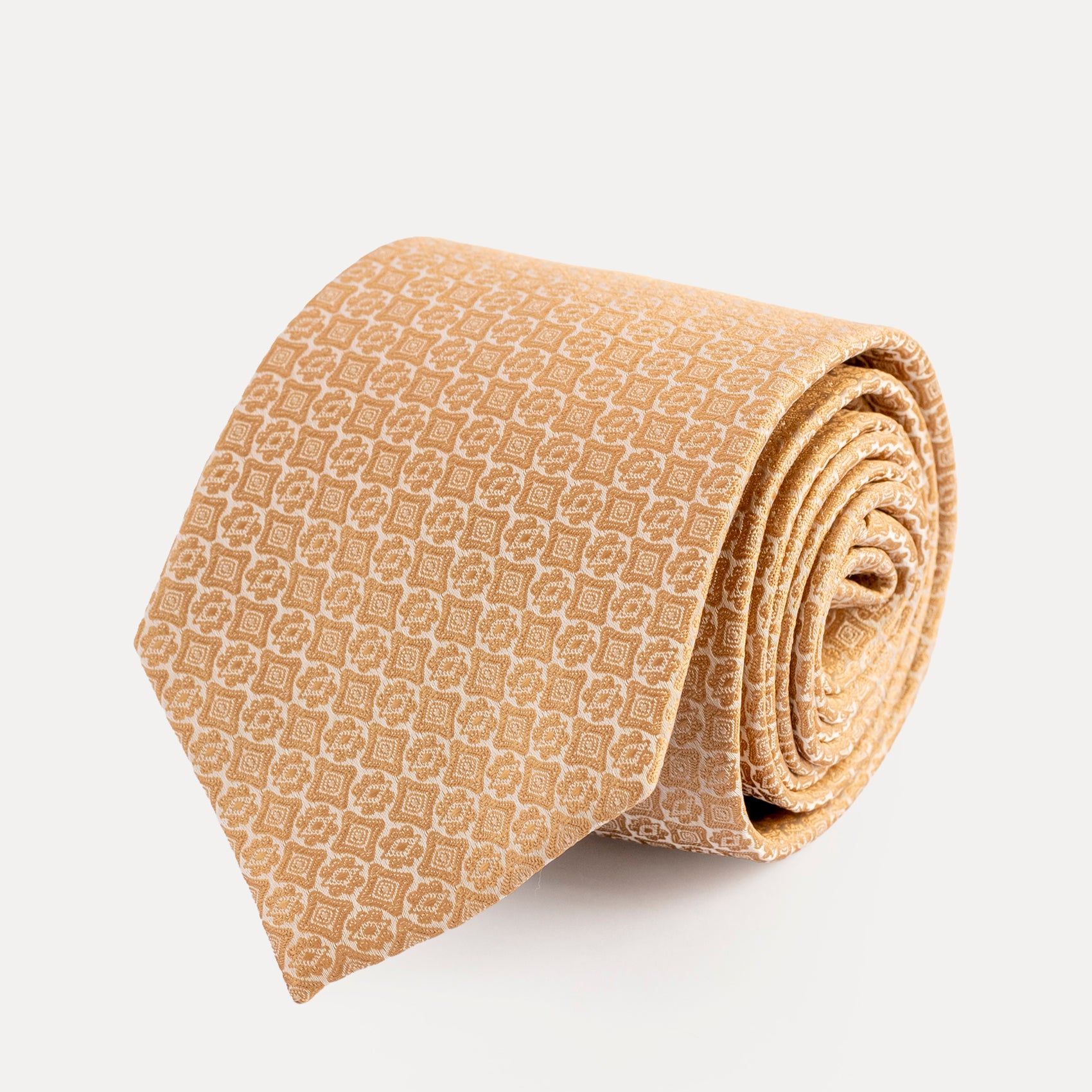 Rolled beige patterned tie on a light gray background