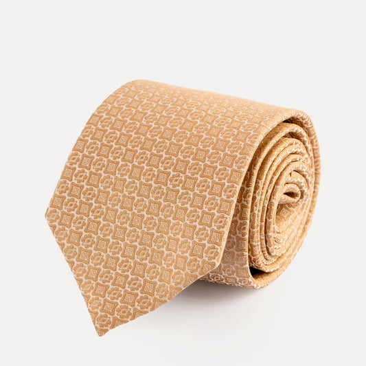 Rolled beige patterned tie on a light gray background