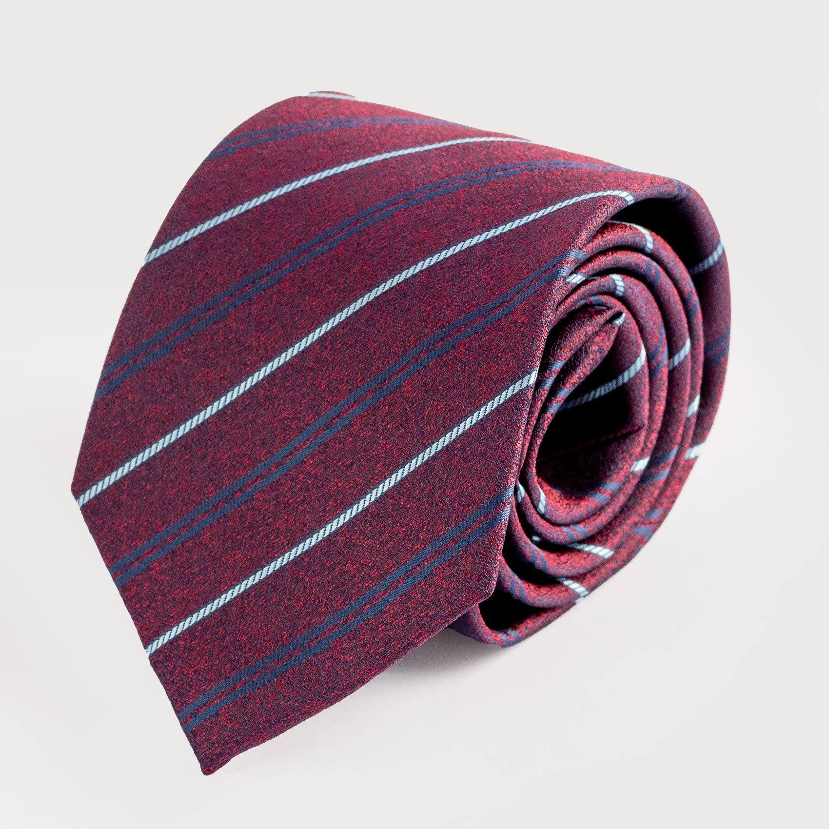 Folded maroon tie with blue stripes on a light gray background