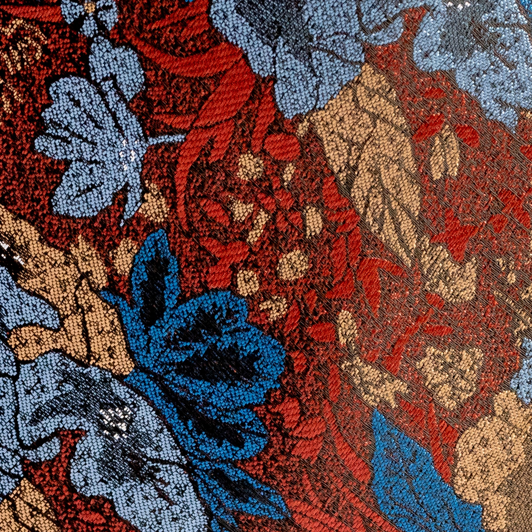Close-up of a floral patterned fabric with red, blue, and beige colors.