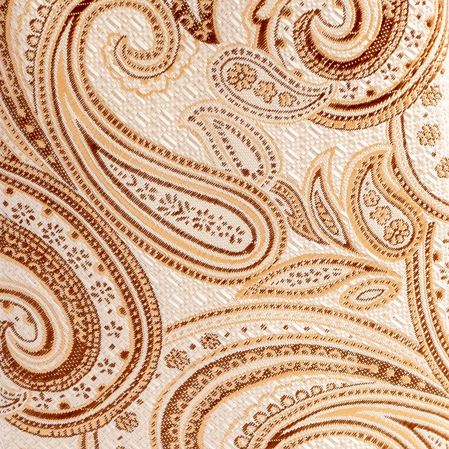 Close-up of a beige and brown paisley pattern fabric texture