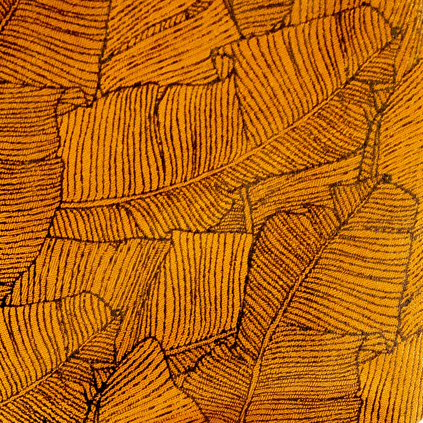 Close-up of a textured yellow fabric with leaf pattern