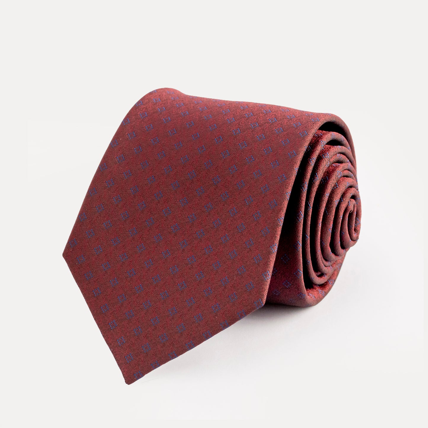 Folded burgundy tie with subtle pattern on a light gray background