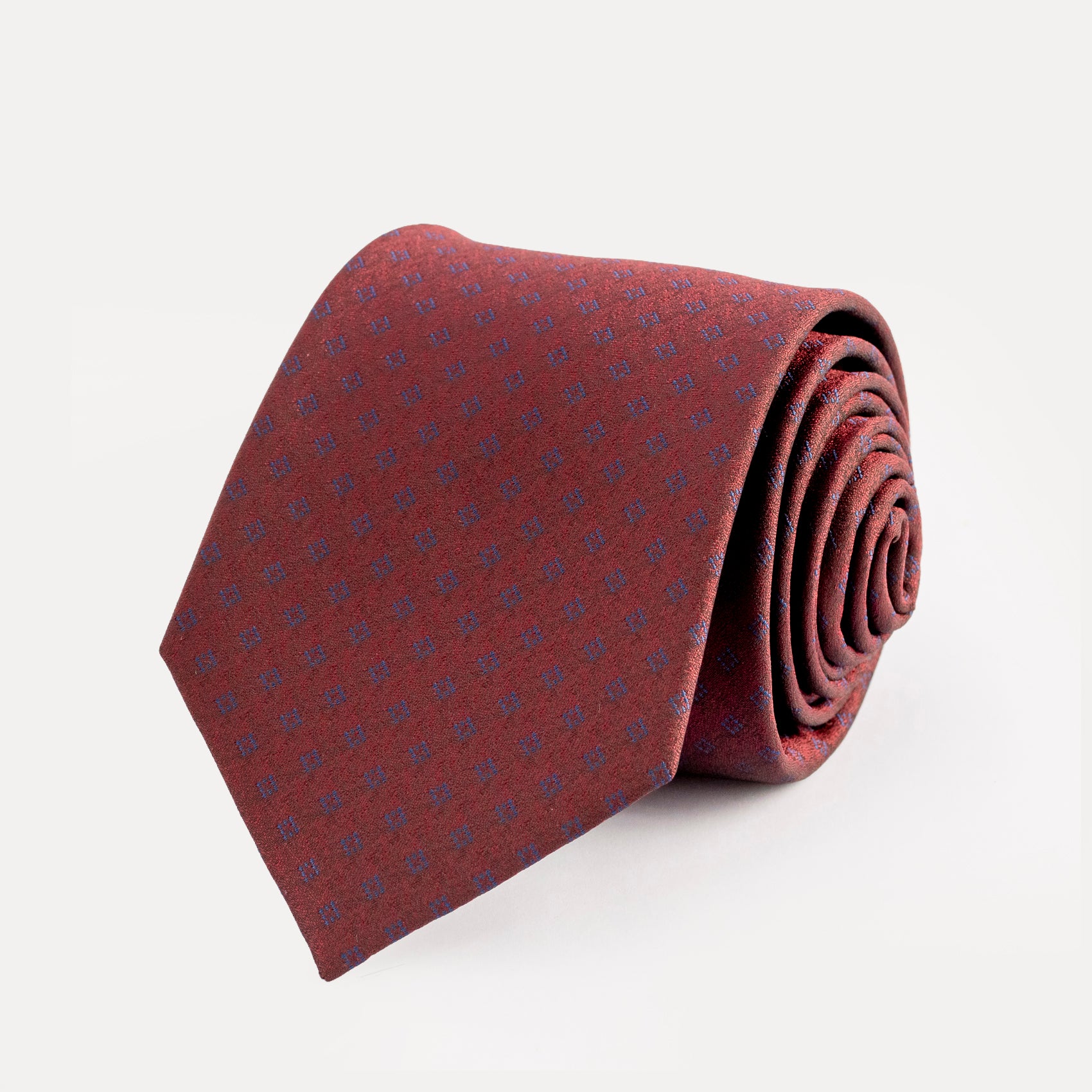 Folded burgundy tie with subtle pattern on a light gray background