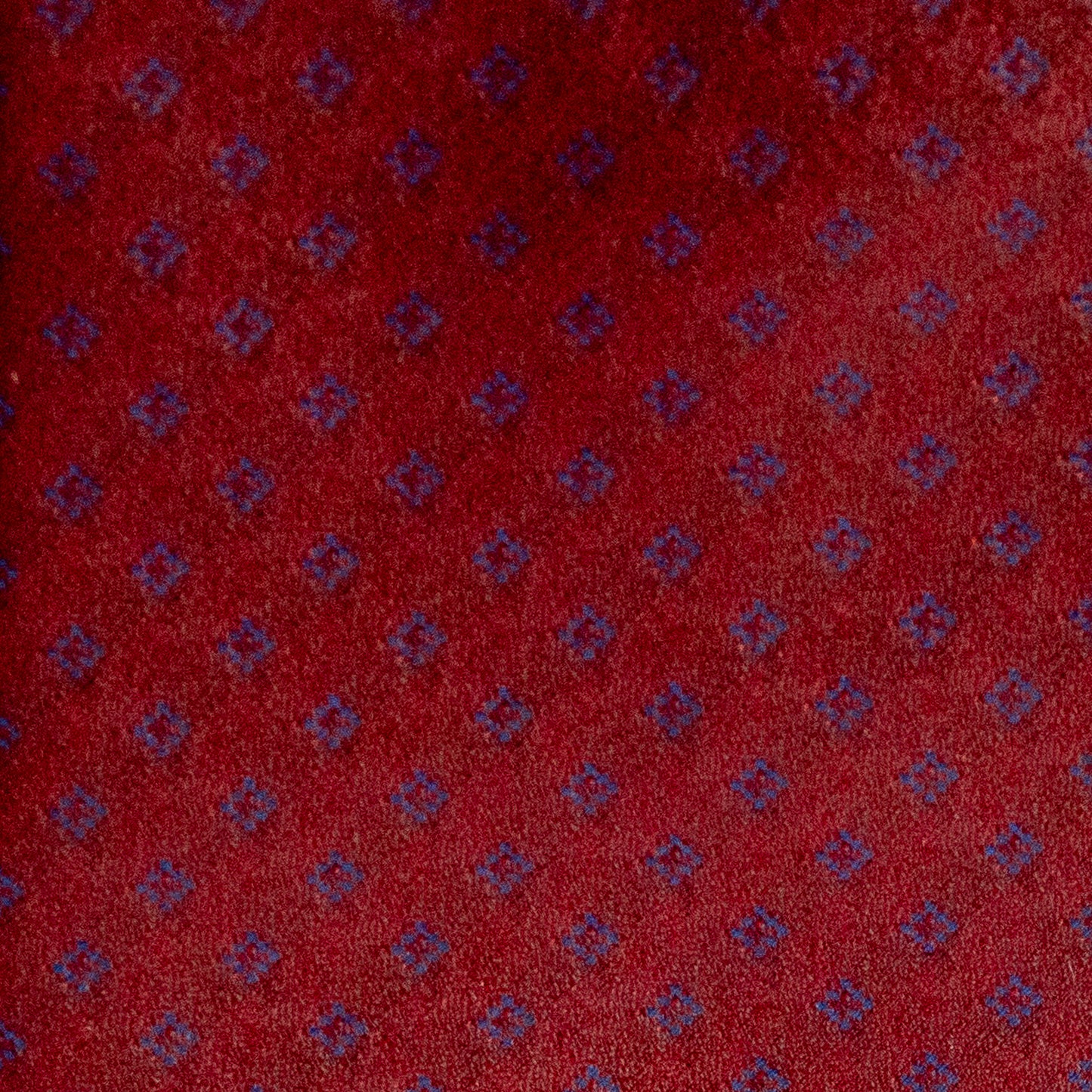 Red fabric with small blue geometric pattern