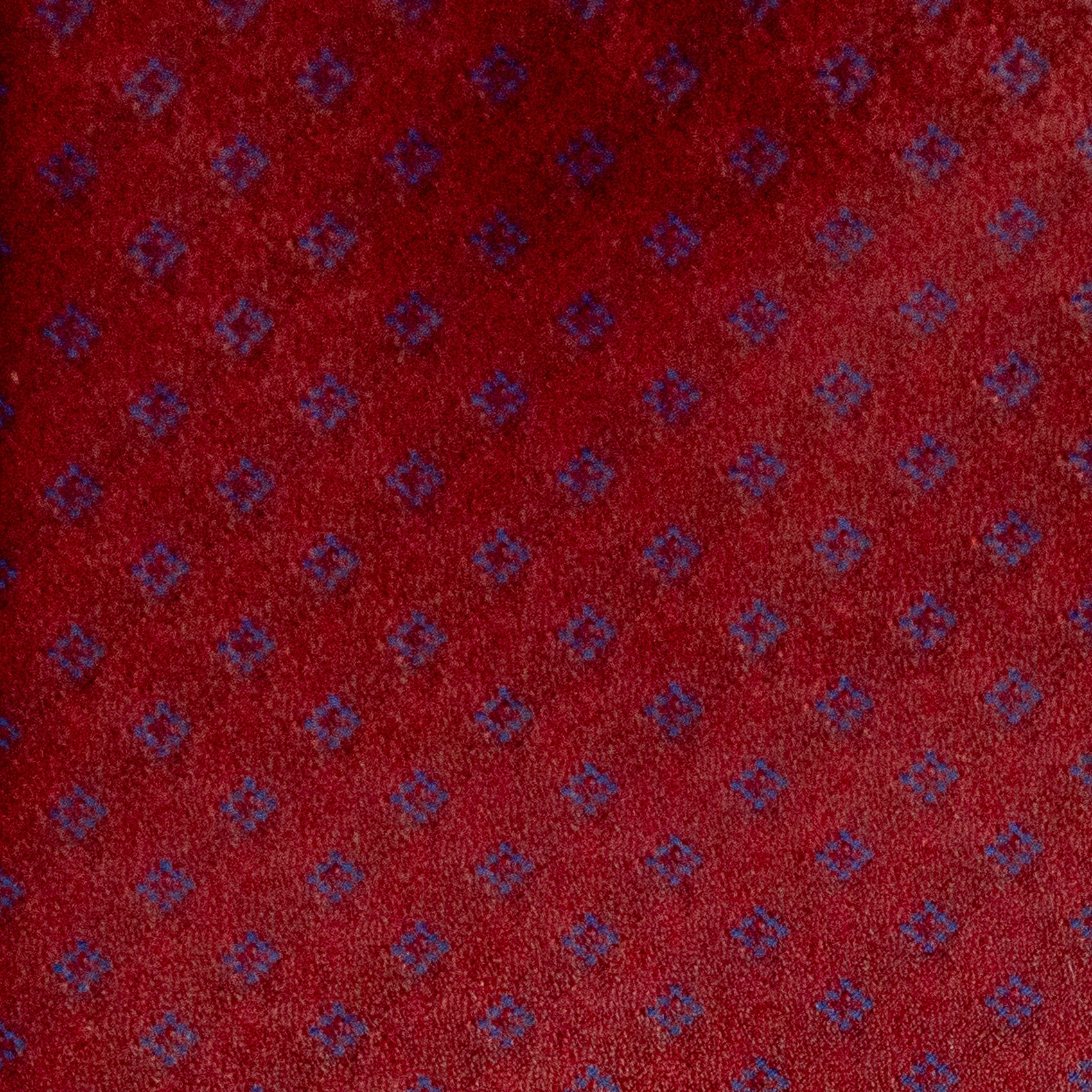 Red fabric with small blue geometric pattern