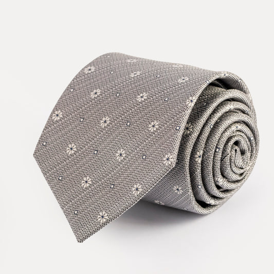 Rolled-up gray tie with subtle pattern on a light gray background