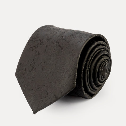 Rolled black tie on a light gray background
