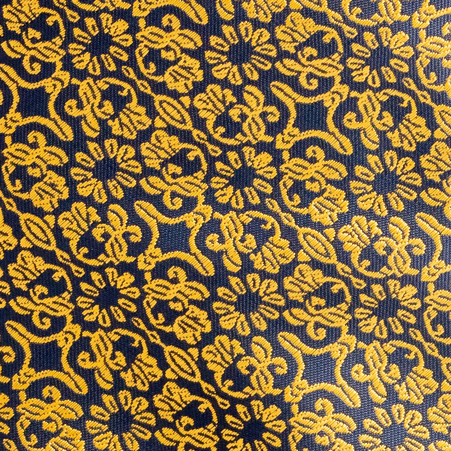 Close-up of a patterned fabric with yellow designs on a blue background