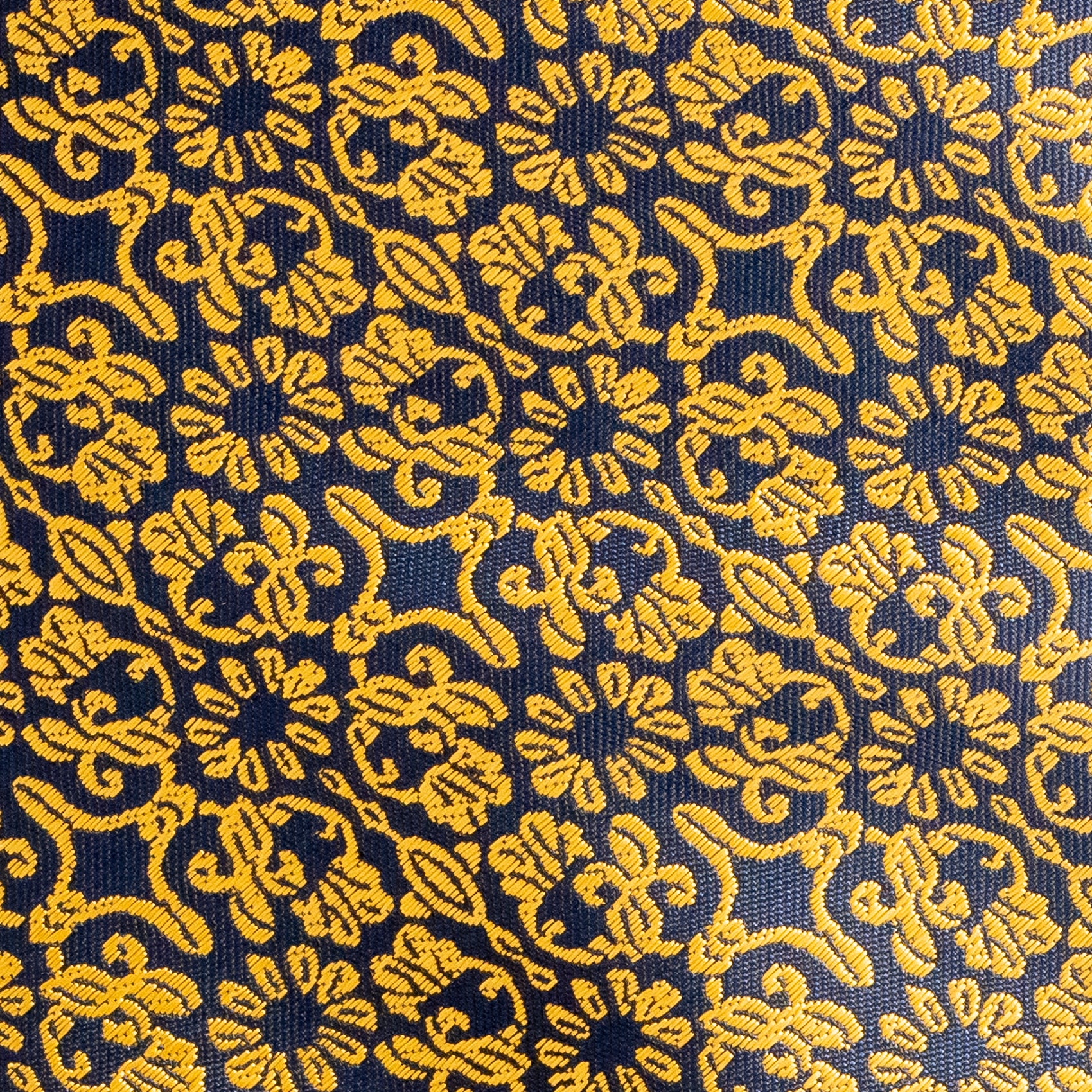 Close-up of a patterned fabric with yellow designs on a blue background