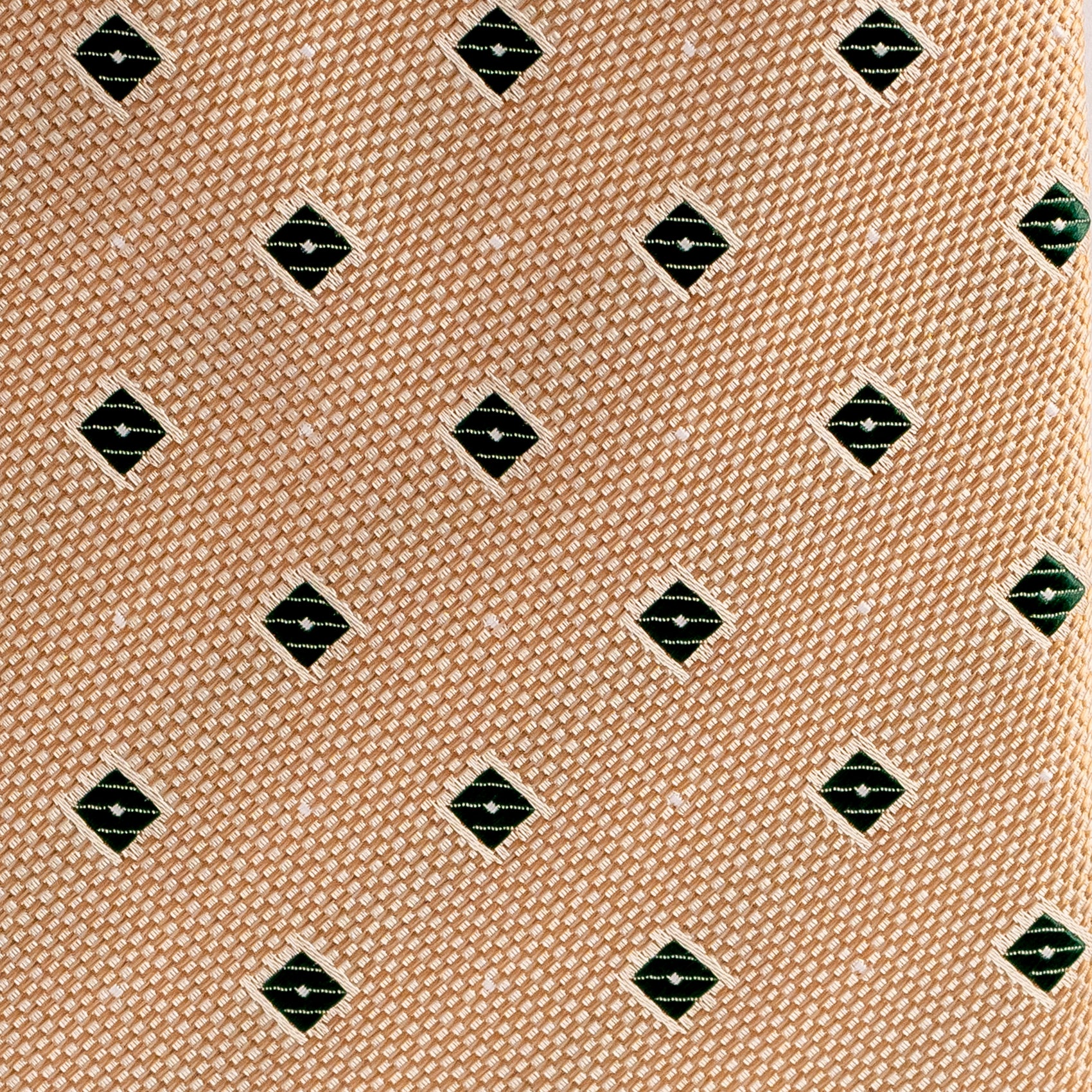 Patterned fabric with black and green diamond shapes on a beige background