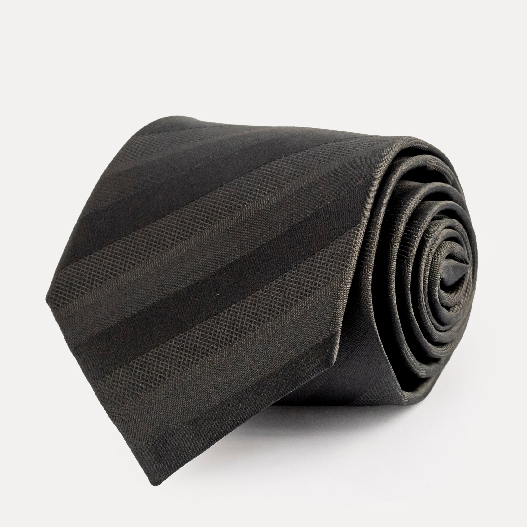 Rolled black tie on a white background