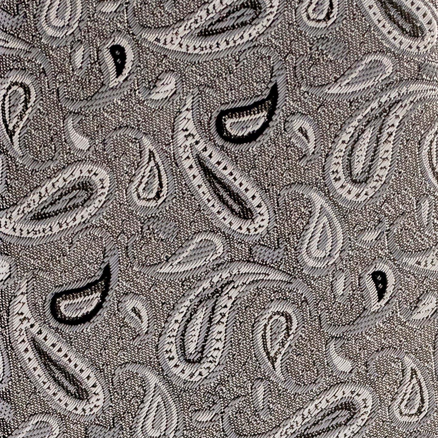 Close-up of a patterned fabric with paisley designs in black and white.