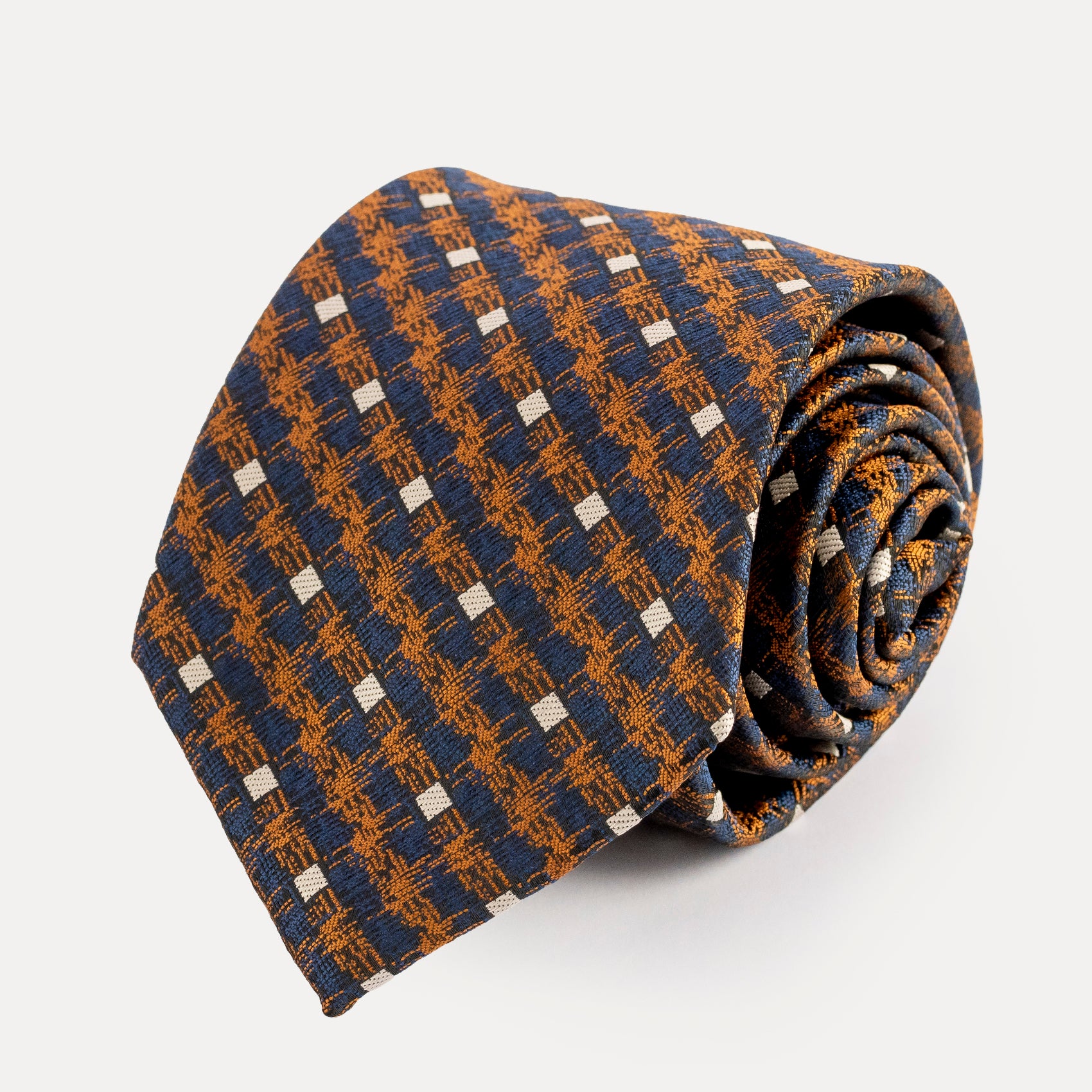 Folded patterned tie on a light gray background