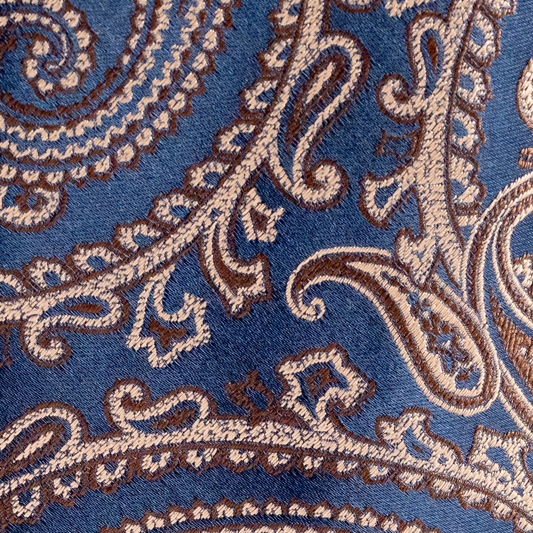 Close-up of a patterned fabric with intricate designs on a blue background