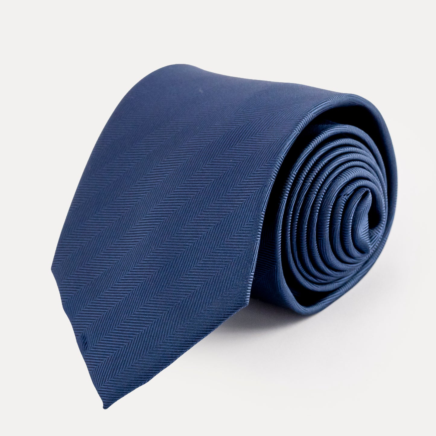 Rolled-up blue tie on a light gray background