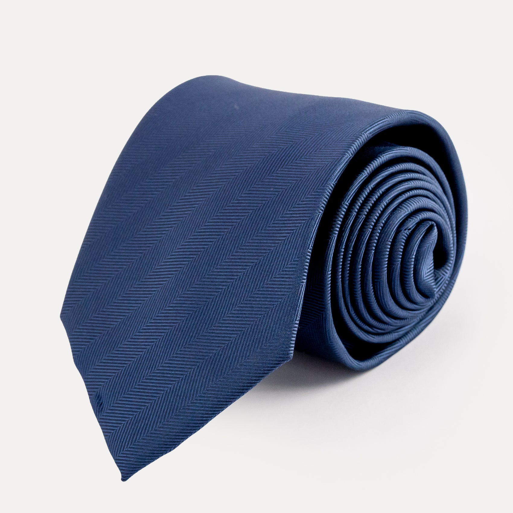 Rolled-up blue tie on a light gray background