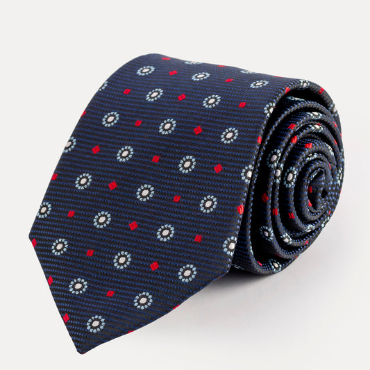 Roll of a navy blue tie with red and white pattern on a light gray background