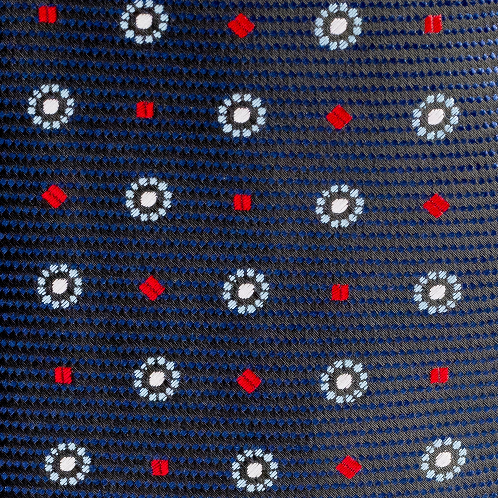Navy blue tie with white floral patterns and red accents