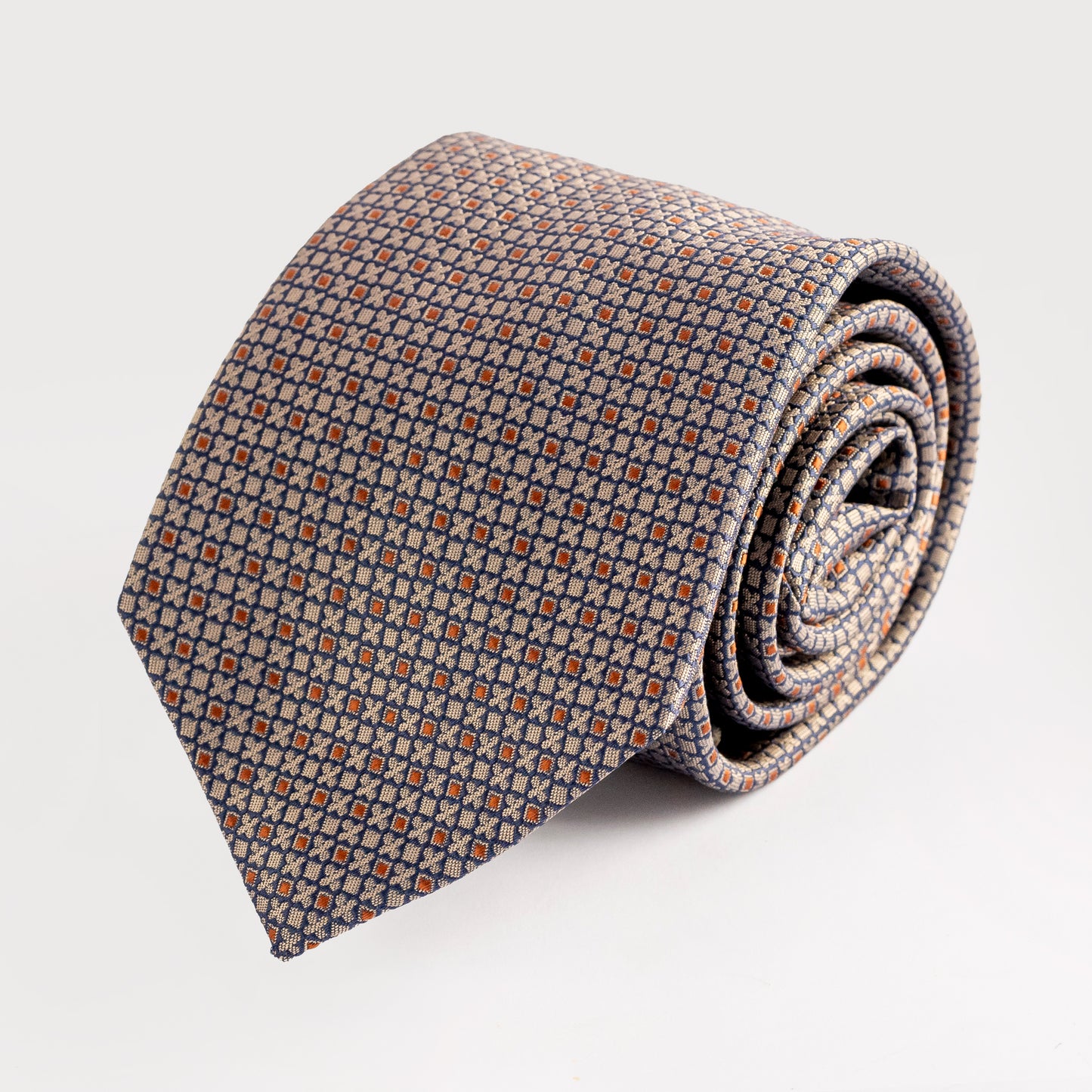 Rolled-up patterned tie on a light gray background