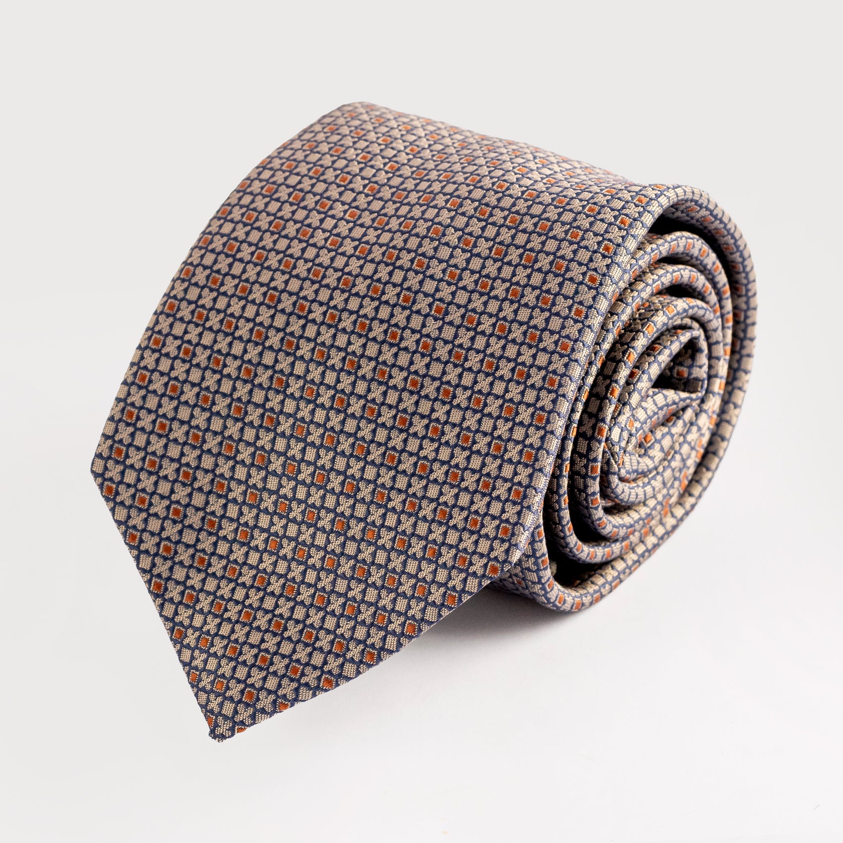 Rolled-up patterned tie on a light gray background
