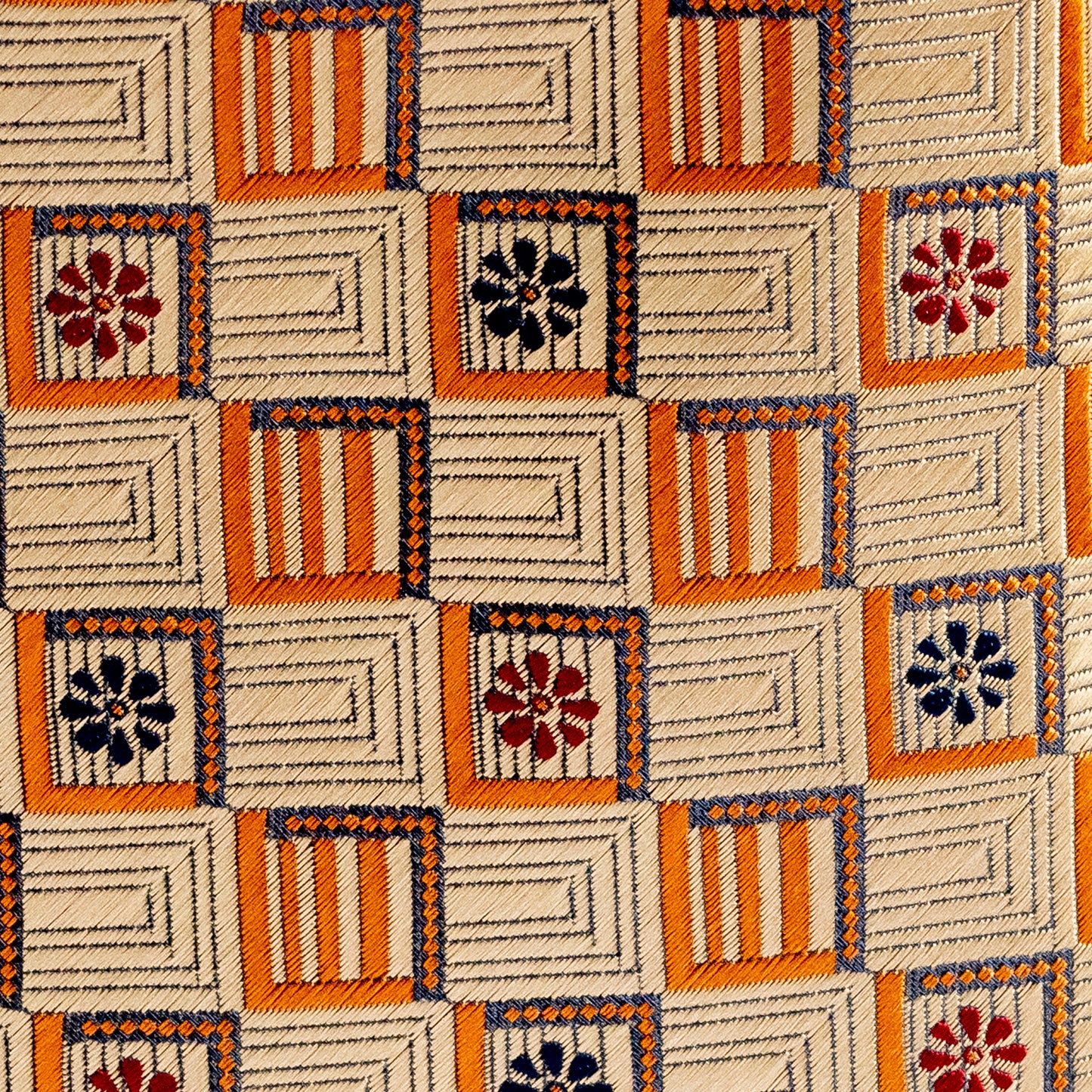 Patterned fabric with geometric shapes and floral designs on a beige background