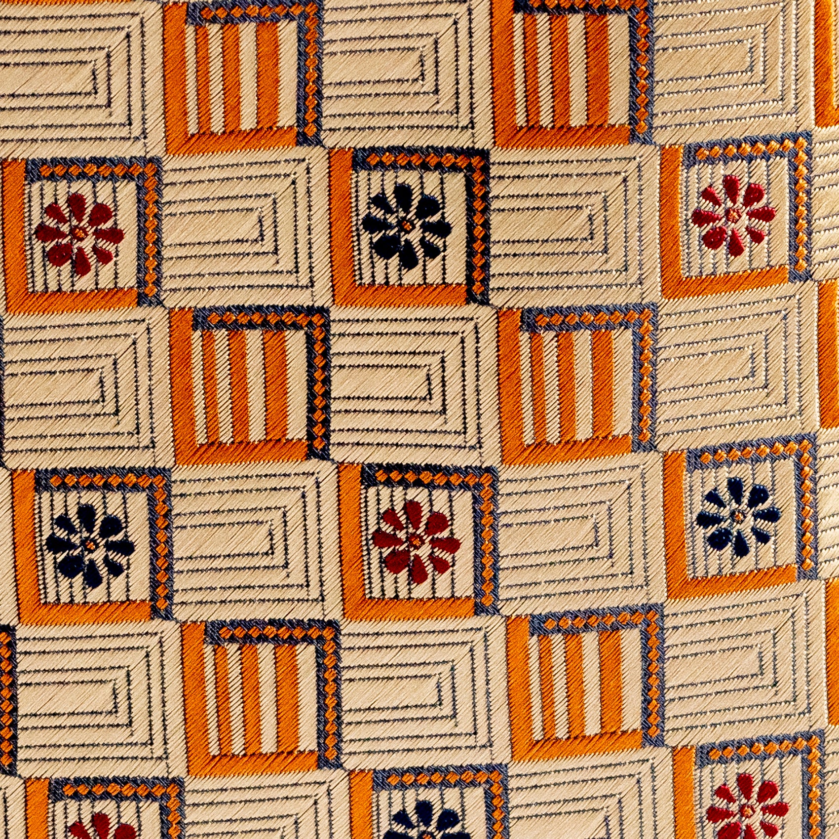 Patterned fabric with geometric shapes and floral designs on a beige background