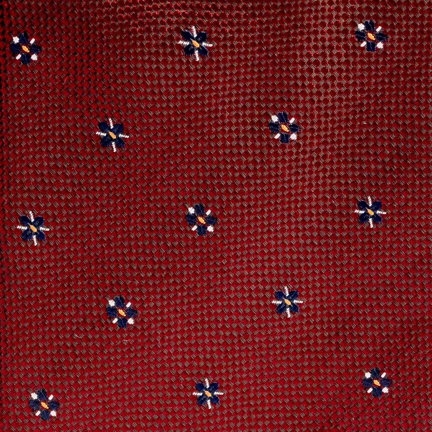 Red patterned fabric with small blue and orange designs