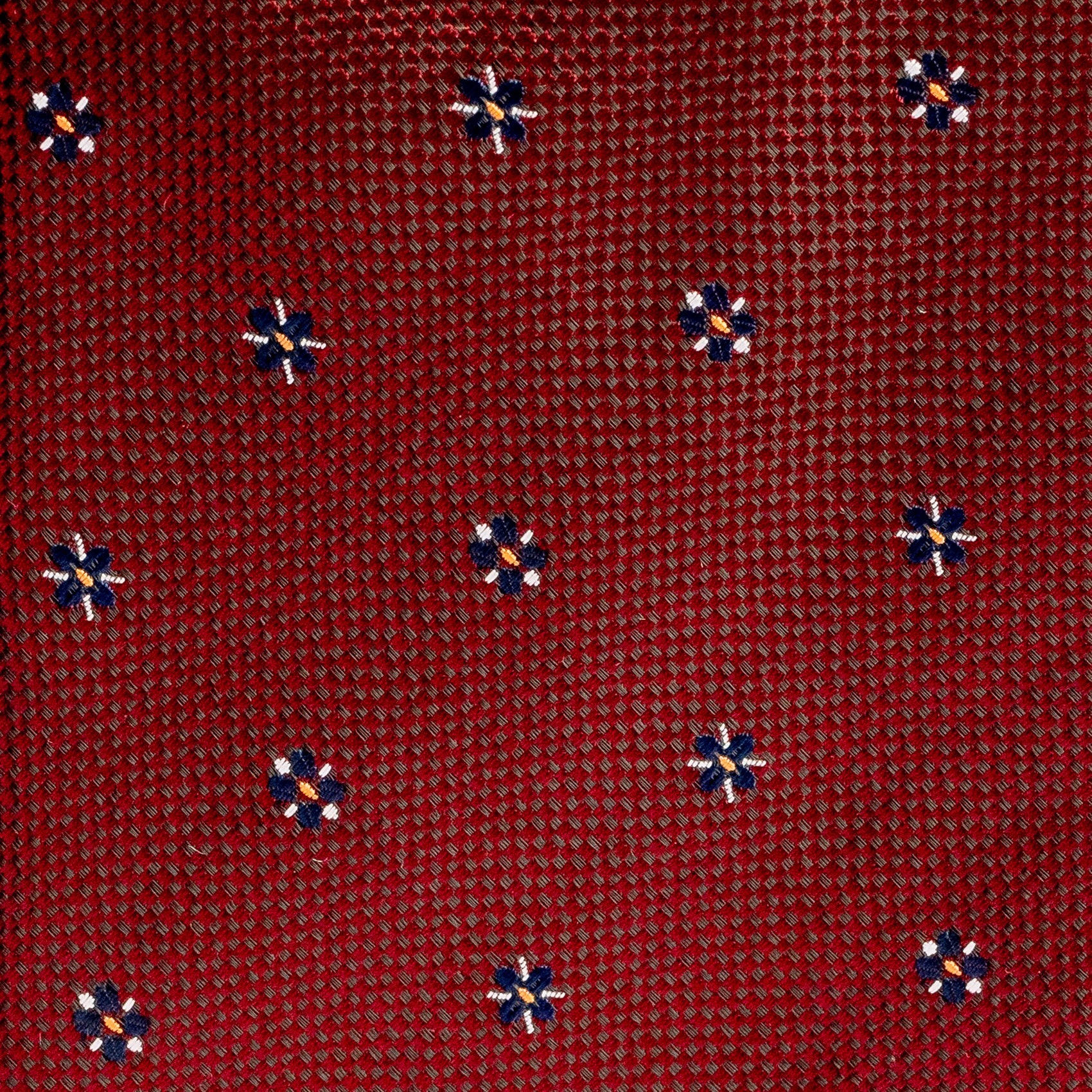Red patterned fabric with small blue and orange designs