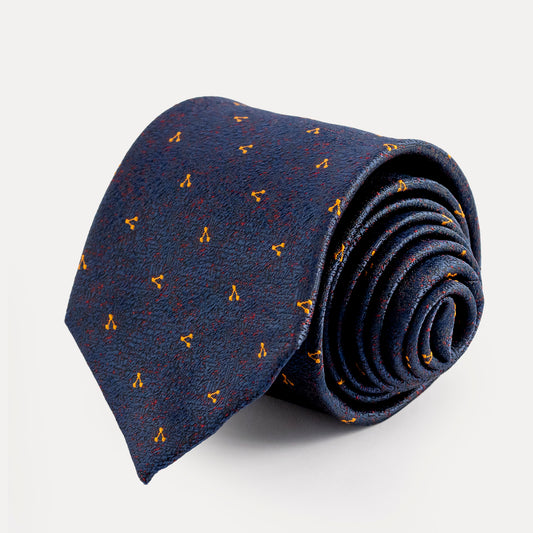 Rolled-up navy blue tie with small yellow patterns on a light gray background