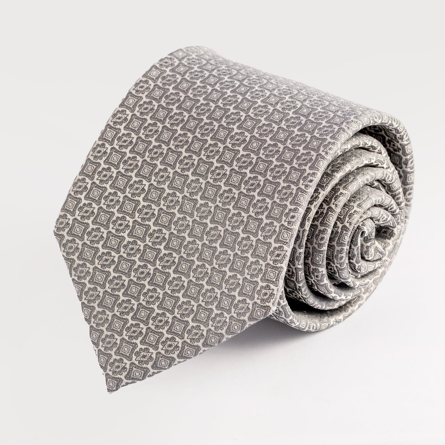 Rolled-up patterned tie on a light gray background