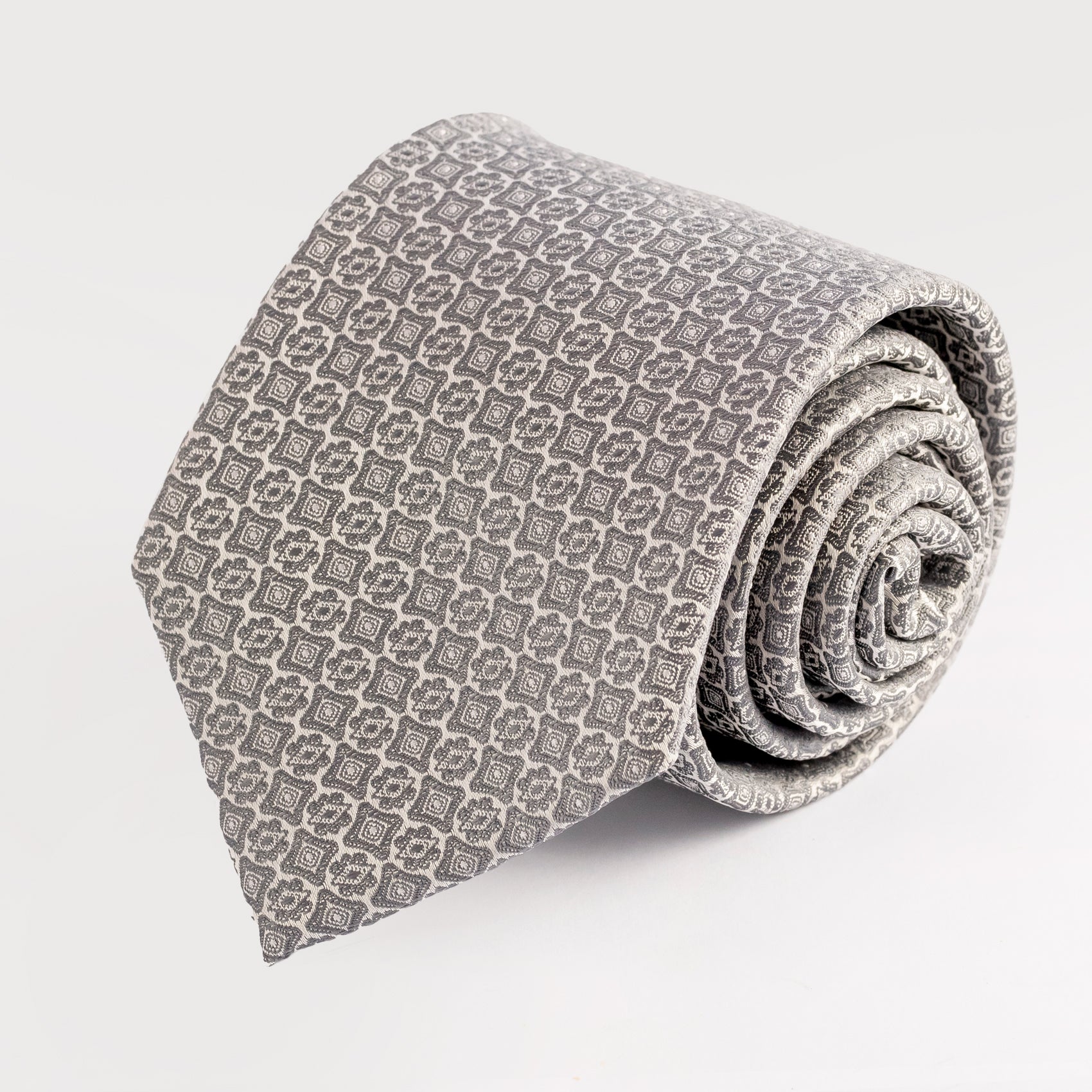 Rolled-up patterned tie on a light gray background
