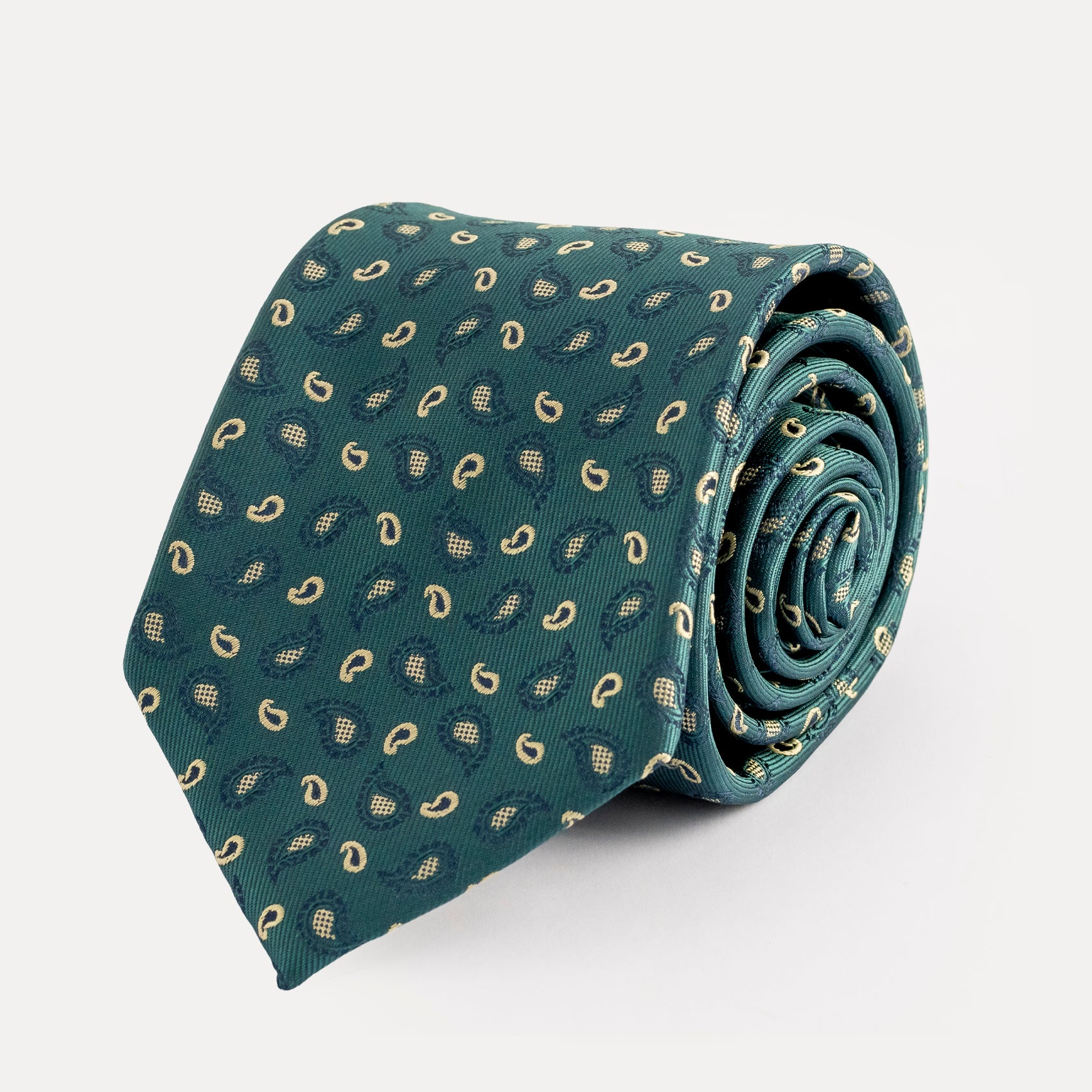 Rolled-up green tie with pattern on a light gray background