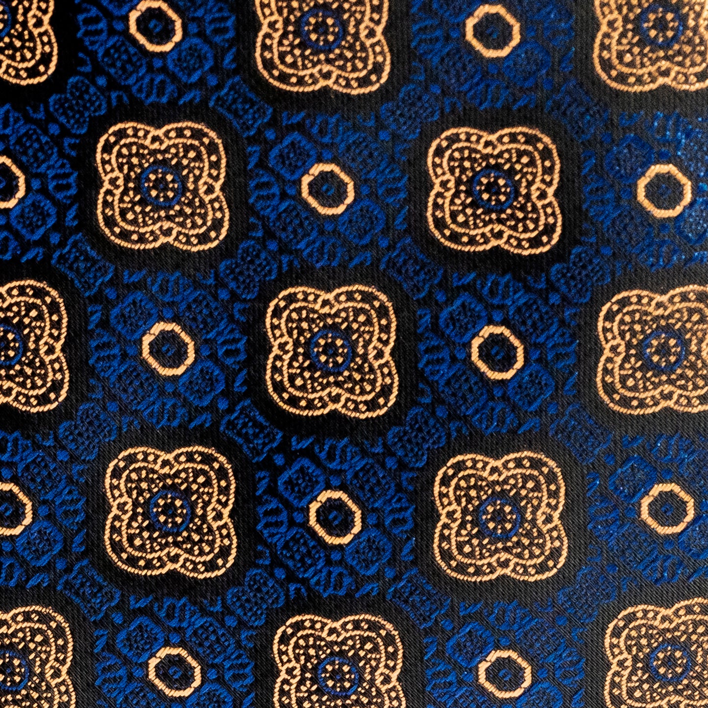Patterned fabric with blue and gold design on a black background