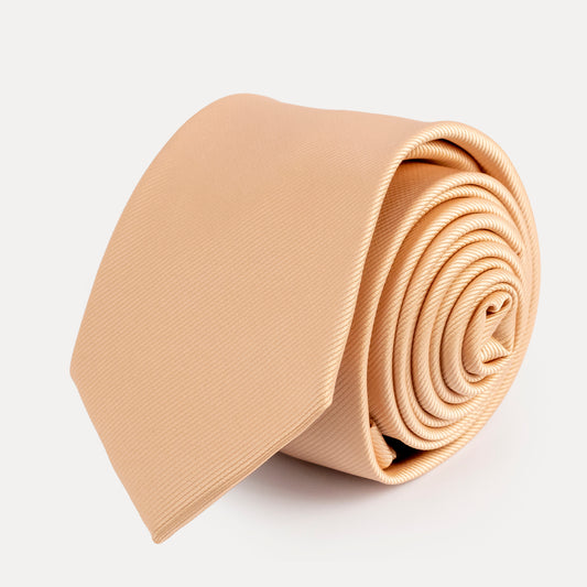 Beige necktie rolled up on a light gray background